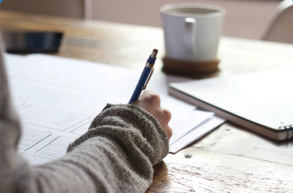 Student writing notes at a study desk